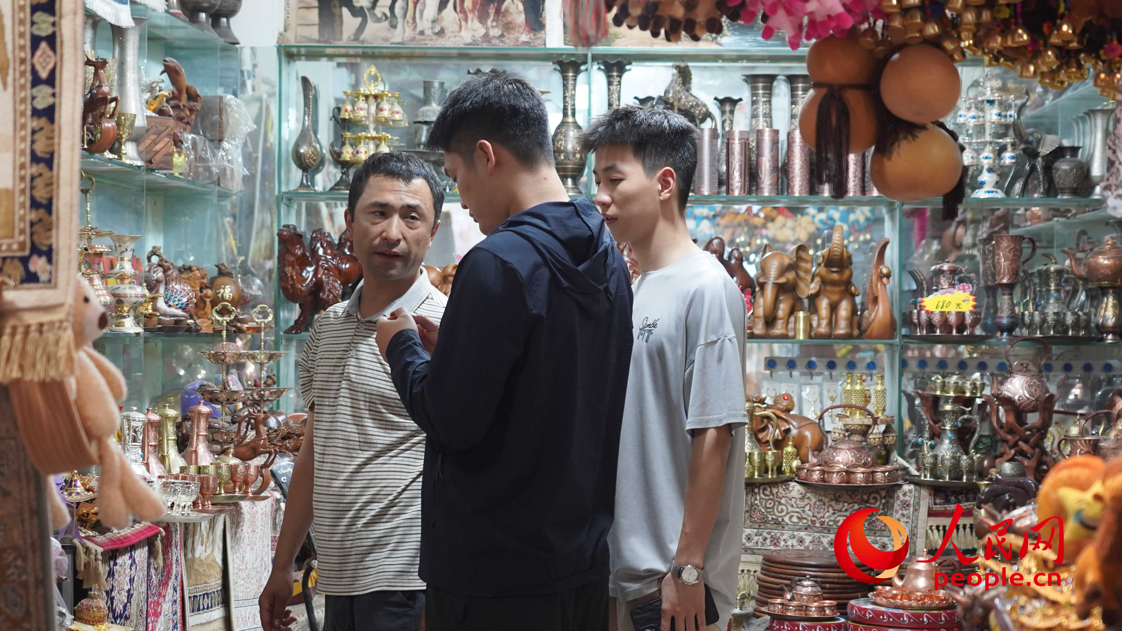 游客正在購(gòu)買工藝品。人民網(wǎng) 李龍攝