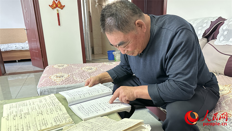青格達(dá)湖鄉(xiāng)天山村村民李強(qiáng)拿出近幾年的賬本查看。人民網(wǎng)記者 楊睿攝