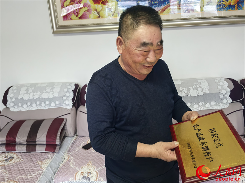 李強(qiáng)向記者展示他獲得的“國(guó)家定點(diǎn)農(nóng)產(chǎn)品成本調(diào)查戶”牌匾。人民網(wǎng)記者 陳新輝攝