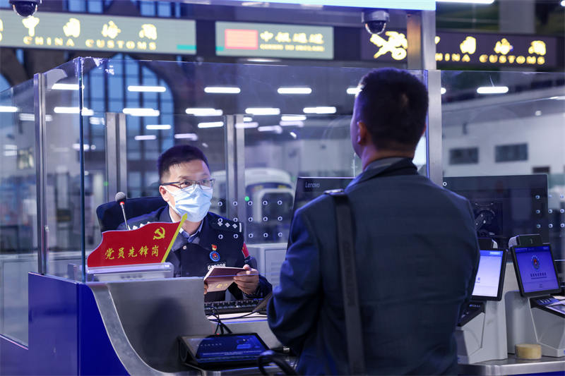 圖為霍爾果斯出入境邊防檢查站民警為入境游客辦理邊檢手續(xù)。宋唯一攝